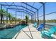Screened pool with waterfall feature and colorful adirondack chairs at 3397 Bluefish Dr, Hernando Beach, FL 34607