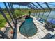 Screened pool with waterfall feature, surrounded by lush landscaping and seating at 3397 Bluefish Dr, Hernando Beach, FL 34607