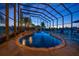 Covered pool with waterfall feature, lush landscaping, and relaxing seating overlooking a lake view at 3397 Bluefish Dr, Hernando Beach, FL 34607