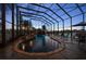 Covered pool with waterfall feature, lush landscaping, and relaxing seating overlooking a lake view at 3397 Bluefish Dr, Hernando Beach, FL 34607