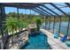 Inviting screened-in pool area features a waterfall, tropical plants, and serene waterfront views at 3397 Bluefish Dr, Hernando Beach, FL 34607