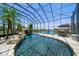 Screened pool with waterfall feature, seating area, and view of the lake at 3397 Bluefish Dr, Hernando Beach, FL 34607