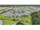Aerial view of a neighborhood with well-maintained houses, green lawns, and community pond at 3541 Great Banyan Way, Wesley Chapel, FL 33543