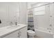 Clean bathroom with a sink, toilet, and a shower-tub combination with a stylish blue and white curtain at 3541 Great Banyan Way, Wesley Chapel, FL 33543
