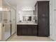 Modern bathroom featuring dark wood cabinets, a large mirror, and a glass-enclosed shower for convenience at 3541 Great Banyan Way, Wesley Chapel, FL 33543