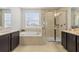 Luxurious bathroom featuring dual vanities, a soaking tub, and a glass-enclosed shower at 3541 Great Banyan Way, Wesley Chapel, FL 33543
