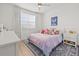 Light-filled bedroom with white furniture and a soft-colored bed, creating a peaceful and airy atmosphere at 3541 Great Banyan Way, Wesley Chapel, FL 33543