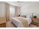 Well-lit bedroom featuring a ceiling fan, plush bedding, and bedside tables with lamps at 3541 Great Banyan Way, Wesley Chapel, FL 33543