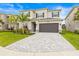 Charming home with a well-kept lawn, lush landscaping, a gray brick driveway, and an attached two-car garage at 3541 Great Banyan Way, Wesley Chapel, FL 33543