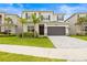 Beautiful two-story home featuring a well-manicured lawn, gray brick driveway, and a two-car garage at 3541 Great Banyan Way, Wesley Chapel, FL 33543