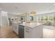 Bright, open-concept kitchen featuring a large island, stainless steel appliances, and modern pendant lighting at 3541 Great Banyan Way, Wesley Chapel, FL 33543