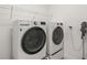 Well-equipped laundry room with front-loading washer and dryer, overhead shelving, and cleaning supplies at 3541 Great Banyan Way, Wesley Chapel, FL 33543