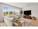 Cozy living room with large windows, hardwood floors, a plush sofa, and a neutral color palette at 3541 Great Banyan Way, Wesley Chapel, FL 33543