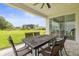 Covered patio with an outdoor dining set and sliding glass doors, ideal for enjoying the backyard view at 3541 Great Banyan Way, Wesley Chapel, FL 33543
