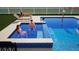 A jacuzzi spills into a swimming pool where a couple is enjoying the sun at 3541 Great Banyan Way, Wesley Chapel, FL 33543