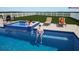 A Gathering enjoys time in a backyard pool and spa, with firepit nearby at 3541 Great Banyan Way, Wesley Chapel, FL 33543