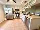Well-lit kitchen with stainless steel appliances, white cabinets, and tiled floor at 3725 Teeside Dr, New Port Richey, FL 34655