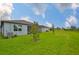 Spacious backyard with lush green grass, landscaping, and exterior of the home at 3816 N Maryland Ave, Plant City, FL 33565