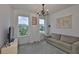 Bright living room featuring plush carpeting, neutral decor, and plenty of natural light from large windows at 3816 N Maryland Ave, Plant City, FL 33565