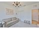 Living room showcasing neutral color palette, elegant chandelier, a closet, and an open doorway to the hall at 3816 N Maryland Ave, Plant City, FL 33565