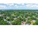 Explore a home with a red pin amid lush greenery in a vibrant residential neighborhood from a scenic aerial perspective at 4028 Queen N St, St Petersburg, FL 33714