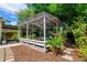 Outdoor patio with a shelter, plants, wood chips, and a stone walkway in the backyard at 4028 Queen N St, St Petersburg, FL 33714