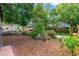 Tranquil backyard featuring mulched area, lush greenery, a fire pit, and a statue at 4028 Queen N St, St Petersburg, FL 33714