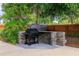 Outdoor grill with a tiled countertop, set amidst well-maintained landscaping, offering a perfect space for cookouts at 4028 Queen N St, St Petersburg, FL 33714
