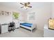 Cozy bedroom with a ceiling fan, desk, and bright natural light from the two windows at 4028 Queen N St, St Petersburg, FL 33714