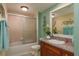 Well-lit bathroom with a shower-tub combo featuring sliding glass doors and a decorative sink and vanity at 4516 Seagull Dr # 601, New Port Richey, FL 34652
