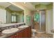 Bathroom featuring double sinks, granite vanity, walk-in shower with glass door, and tiled flooring at 4516 Seagull Dr # 601, New Port Richey, FL 34652