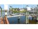 Boat lift system over waterway, with residential buildings and palms in the background at 4516 Seagull Dr # 601, New Port Richey, FL 34652