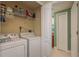Functional laundry area with washer, dryer, overhead storage, and easy access to the nearby bathroom at 4516 Seagull Dr # 601, New Port Richey, FL 34652