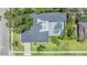 Aerial shot of house featuring enclosed pool, lush landscaping and dark shingled roof at 475 Holly Hill Rd, Oldsmar, FL 34677