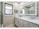 Modern bathroom with double sinks, white cabinets, large mirror, and tile flooring at 475 Holly Hill Rd, Oldsmar, FL 34677