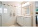 Well-lit bathroom features vanity, mirror, and a walk-in shower with tile surround at 475 Holly Hill Rd, Oldsmar, FL 34677