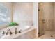 A relaxing bathtub area with garden view, complemented by a separate glass shower at 475 Holly Hill Rd, Oldsmar, FL 34677