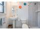 Bright bathroom with a pedestal sink, tiled shower, and colorful decorative accents at 475 Holly Hill Rd, Oldsmar, FL 34677