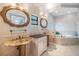 Bathroom featuring double sink vanity, decorative mirrors, and an oval bathtub at 475 Holly Hill Rd, Oldsmar, FL 34677
