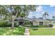 Single-story home with mature trees, green lawn, and manicured landscaping at 475 Holly Hill Rd, Oldsmar, FL 34677