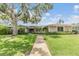 Beautiful home exterior with mature landscaping and shade tree in the front yard at 475 Holly Hill Rd, Oldsmar, FL 34677