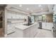 Well-lit modern kitchen with white cabinetry, stainless steel appliances, and center island at 475 Holly Hill Rd, Oldsmar, FL 34677