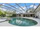 Large screened pool area with spa, covered patio, and surrounding greenery at 475 Holly Hill Rd, Oldsmar, FL 34677