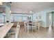 Bright, open-concept dining area with light wood floors, a modern table, and picturesque water views at 500 20Th Ave, Indian Rocks Beach, FL 33785