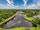 Aerial view of community pond, surrounded by lush greenery and homes with well-kept lawns at 5016 Cypress Trace Dr, Tampa, FL 33624