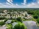 Overhead view showcasing a vast neighborhood near a pond with mature trees and cloudy skies at 5016 Cypress Trace Dr, Tampa, FL 33624