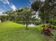Serene backyard view with a beautifully landscaped yard leading to a tranquil pond at 5016 Cypress Trace Dr, Tampa, FL 33624