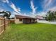 Fenced backyard featuring an enclosed patio, green grass and access to neighbor's yard at 5016 Cypress Trace Dr, Tampa, FL 33624