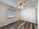 Cozy bedroom showcasing wood-look floors, a ceiling fan, and window with blinds for privacy at 5016 Cypress Trace Dr, Tampa, FL 33624