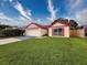 Charming one story single-Gathering home with a manicured lawn and bright red trim at 5016 Cypress Trace Dr, Tampa, FL 33624